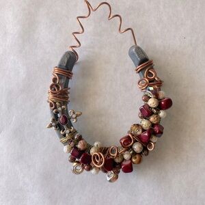 Horse shoe wall decor. Hand decorated with beads and copper wire.